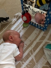 a baby looking in the mirror during tummy time